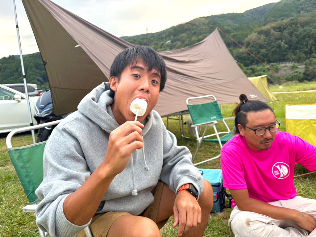 キャンプファイヤーでマシュマロを食べるフープファームメンバー